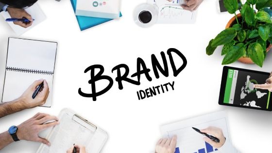 Brand Identity picture with hands and notepads on a desk - Visual Identity in Graphic Design - Image