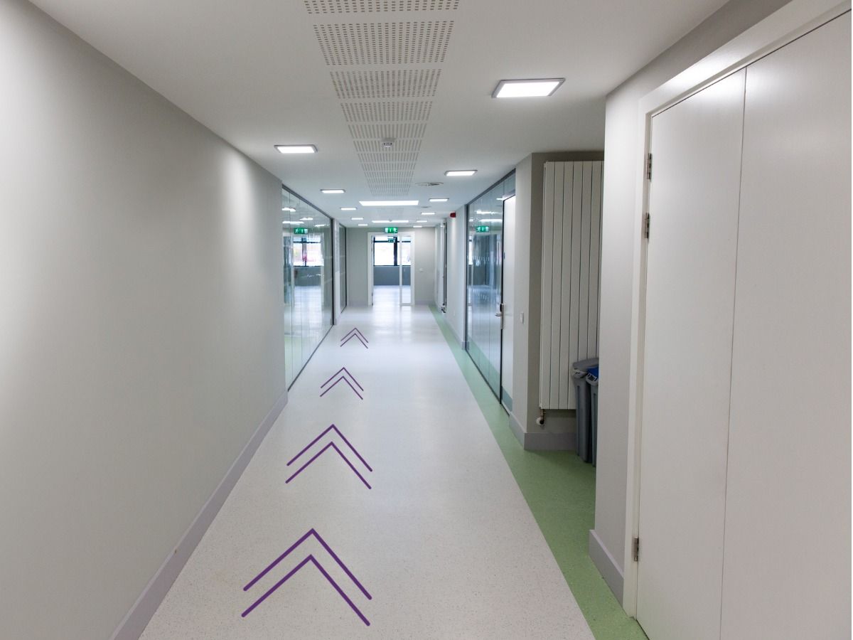 View of a corridor in an office building with arrows on the floor - Design as a tool for effectively connecting people with the environment - Image