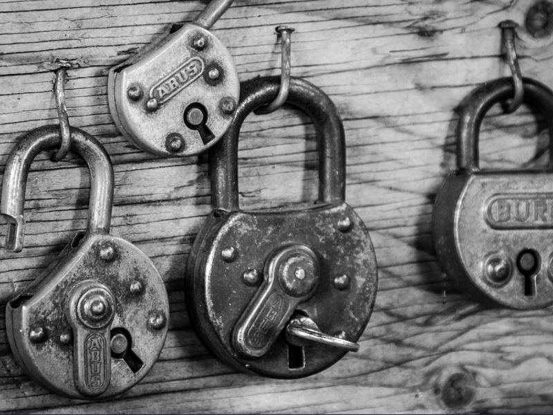 Monochrome image with four padlocks - An escape room is a great birthday party idea that allows everyone to work as a team - Image
