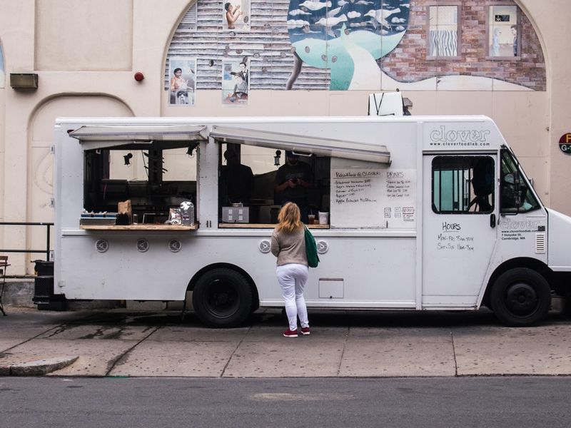 A woman buys food from a food truck - Tips for serving fish and chips - Image