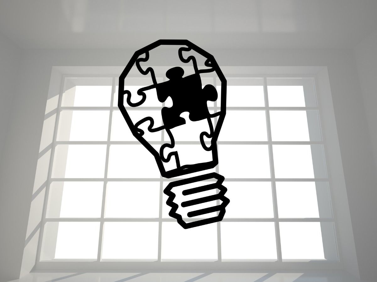 Illustration with a black puzzle light bulb on a light background - Benefits of using black and white colors for branding purposes - Image