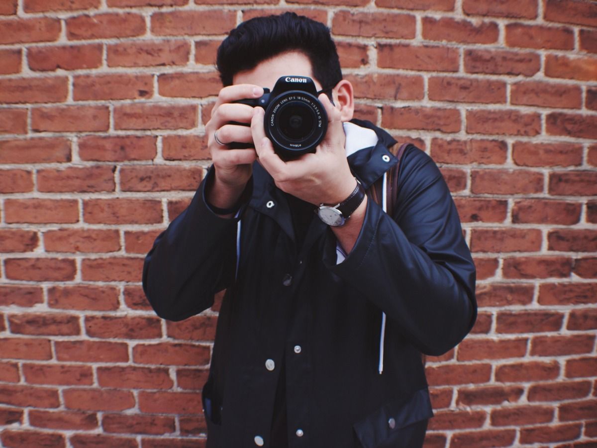 Photographer against a red brick wall - Image licensing - Image