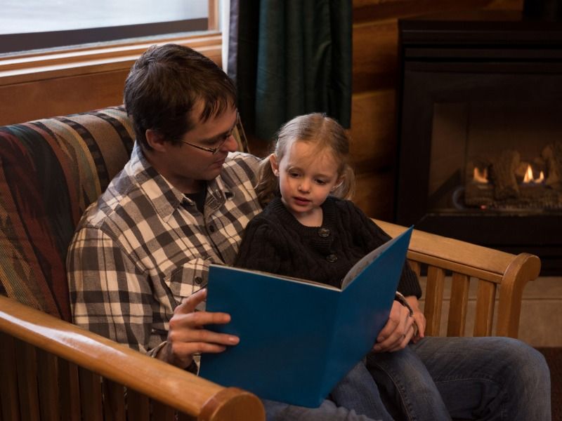 Father reading story book to daughter - A guide to storytelling marketing - Image