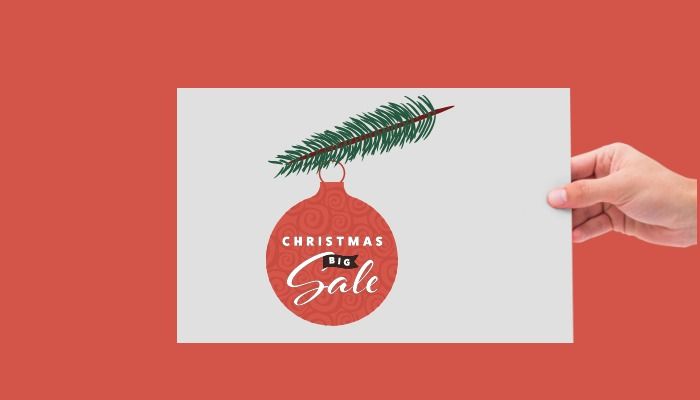 Hand holding card with illustration of pine tree branch and Christmas bauble with text Christmas Big Sale - Top 50 free high-quality design resources for designers and entrepreneurs - Image