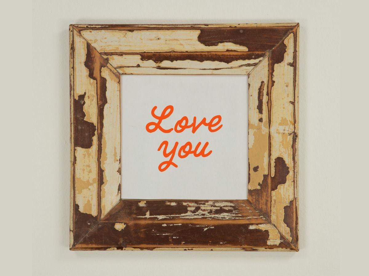 la palabra amor enmarcada en un marco de madera gastado