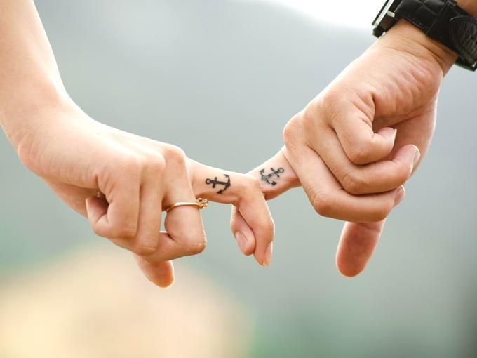 An image of a couple with interlocked index fingers and anchor tattoos on them - 80 Creative and inspiring engagement party ideas - Image