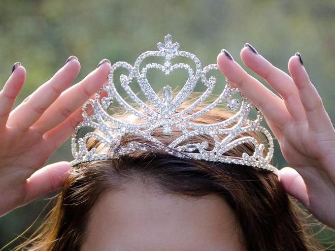 A young woman puts a crown on her head - 80 Creative and inspiring engagement party ideas - Image