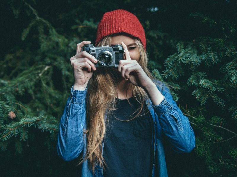 femme prenant une photo avec des arbres en arrière-plan - Comment créer un vlog - Image