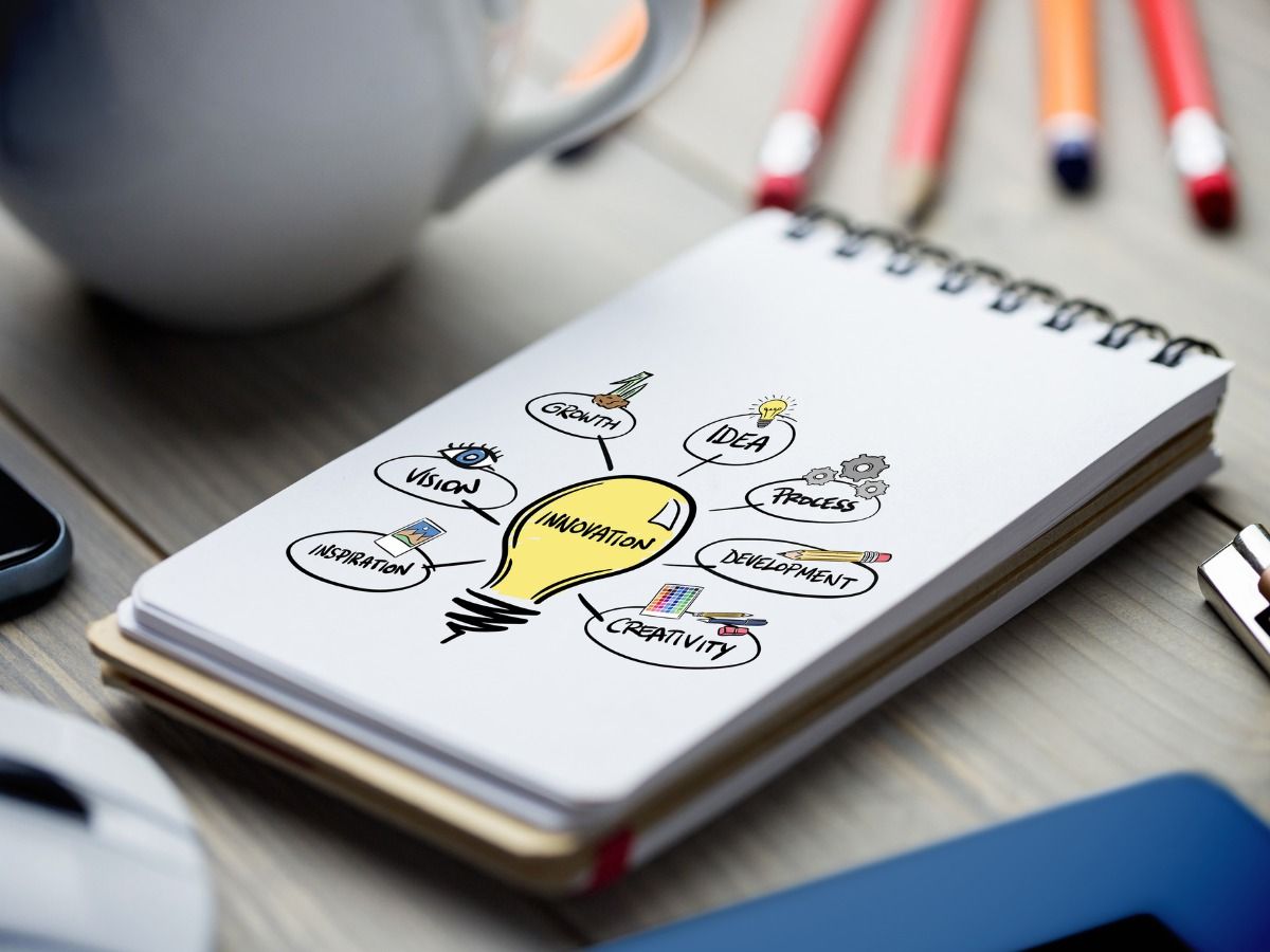 A notepad with a drawn light bulb lies on the table, innovation concept - The key to a successful presentation - Image
