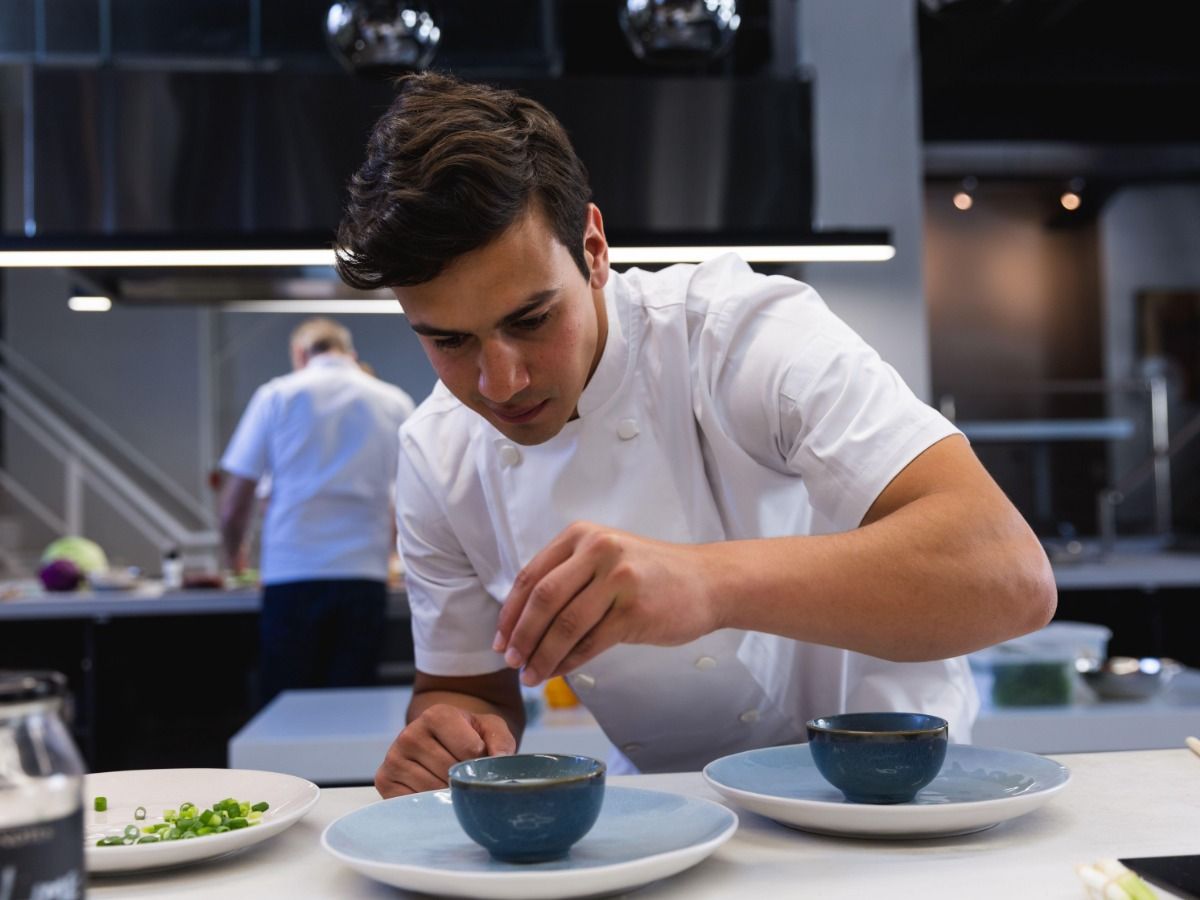 Chef plating a dish in a bowl - Restaurant marketing ideas: how to attract new customers to your restaurant - Image