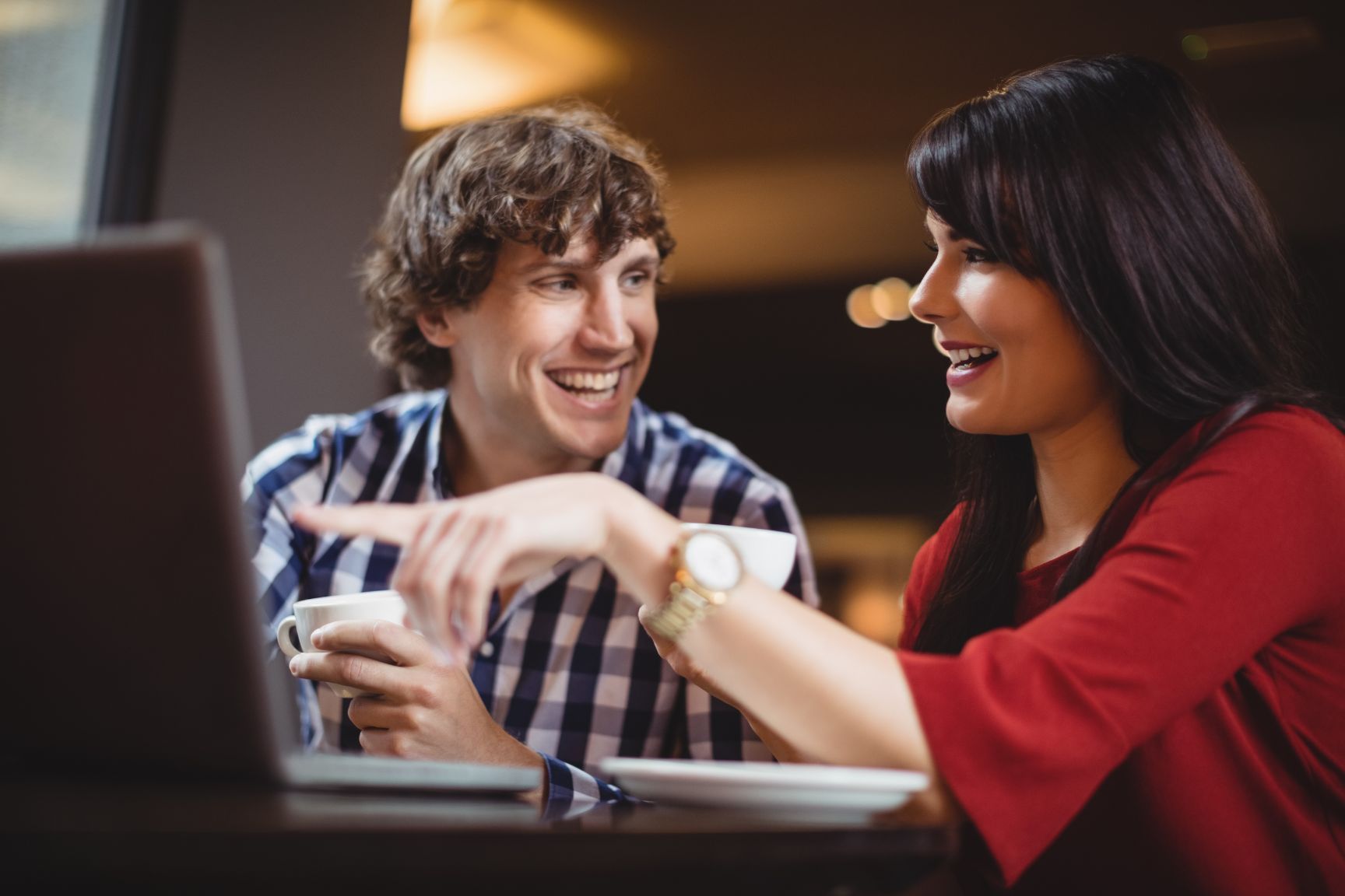 Man and woman at laptop laughing - Twenty-eight helpful sales strategy ideas for boosting your business growth - Image