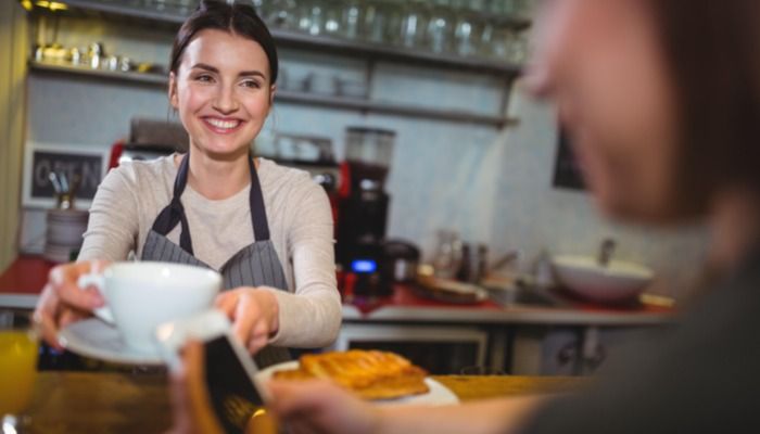 Barista serving coffee to customer - The ultimate guide to relationship marketing - Image