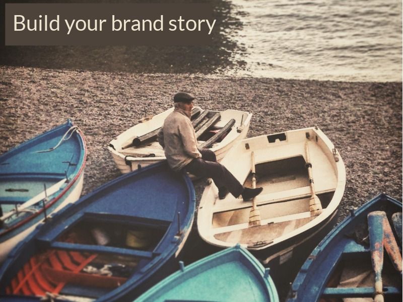 homme assis sur la proue d&#39;un bateau sur une plage avec texte construire notre histoire de marque