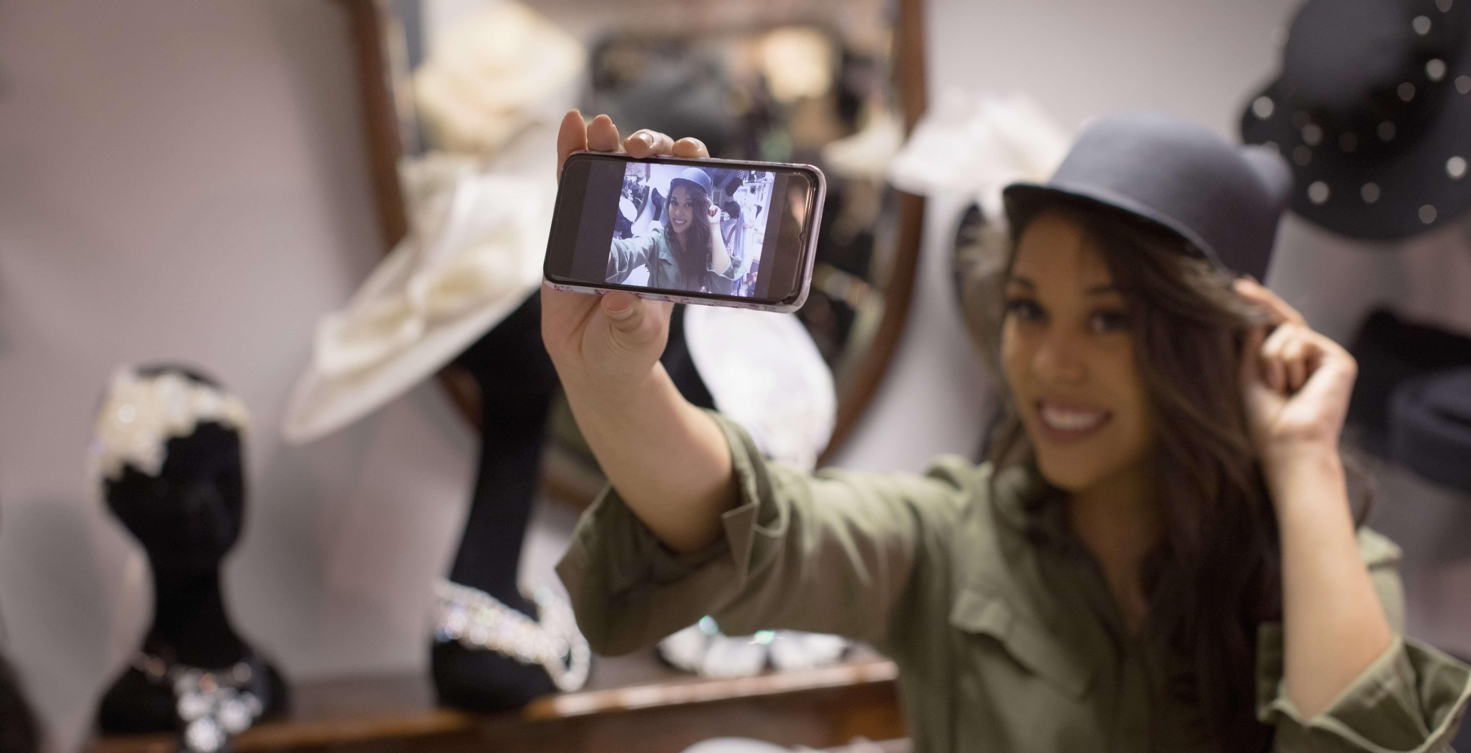 A young woman takes a selfie with a hat - How can visual commerce benefit your business - Image